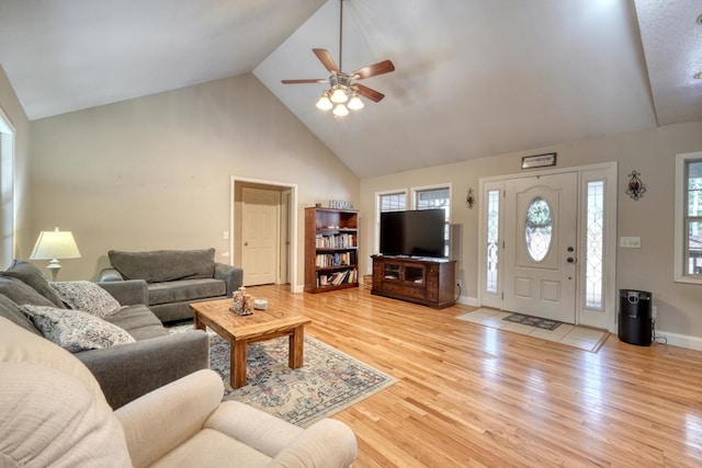 living room featuring ceiling fan, light hardwood / wood-style flooring, and high vaulted ceiling