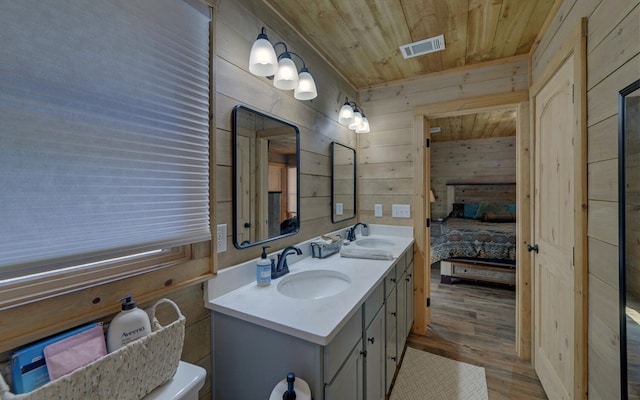 bathroom featuring wood ceiling, visible vents, a sink, and ensuite bathroom