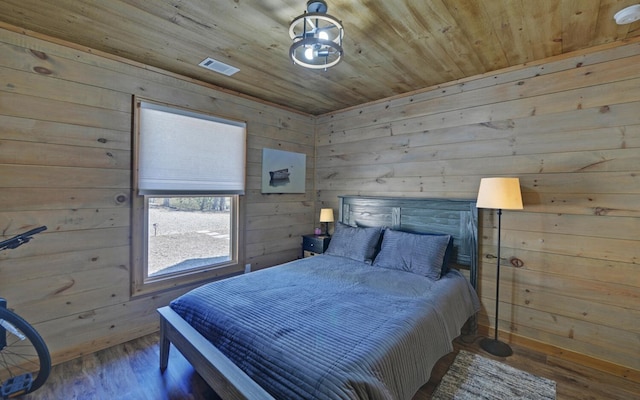 bedroom featuring wood ceiling, wooden walls, and wood finished floors