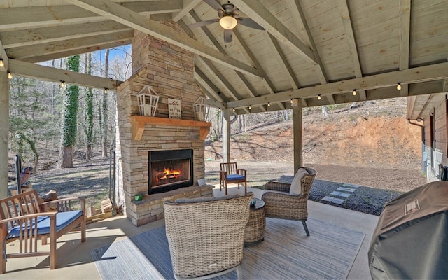 wooden terrace featuring a ceiling fan, a patio, and an outdoor living space with a fireplace