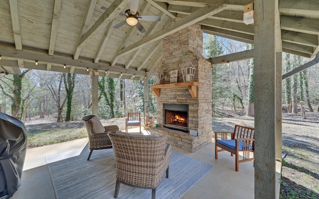 view of patio / terrace with a ceiling fan and an outdoor stone fireplace