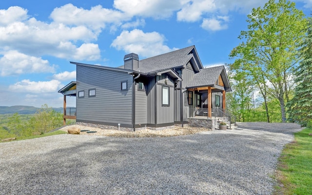 433 Hawkeye Trl, Marble, NC 28905 - view of side of property with a chimney, a porch, board and batten siding, a shingled roof, and driveway