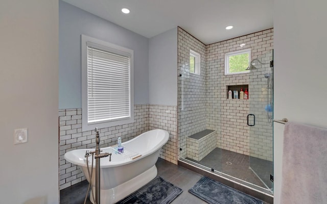 433 Hawkeye Trl, Marble, NC 28905 - full bathroom featuring a soaking tub, a shower stall, recessed lighting, tile walls, and wainscoting