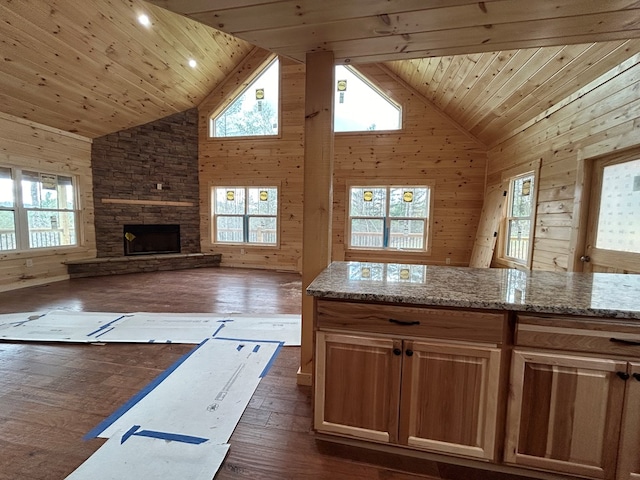 kitchen featuring wood walls, dark hardwood / wood-style flooring, light stone counters, plenty of natural light, and wooden ceiling