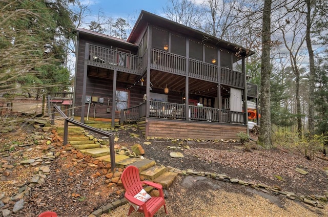 rear view of property featuring stairs and a sunroom