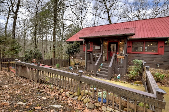 view of front of property with metal roof and fence