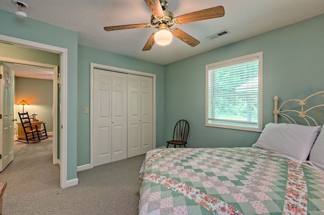 carpeted bedroom featuring ceiling fan and a closet