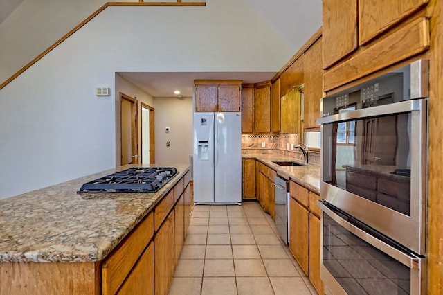 kitchen with light tile patterned floors, a sink, white refrigerator with ice dispenser, black gas cooktop, and a center island