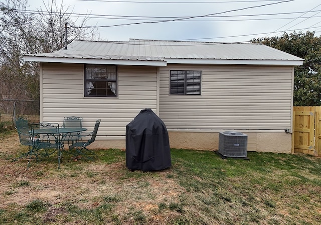 back of house with a lawn and central air condition unit