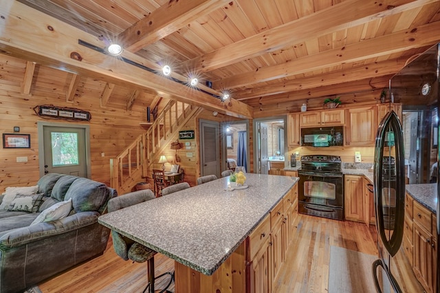 56 Laurel Dr, Blue Ridge, GA 30513 - kitchen with black appliances, open floor plan, a breakfast bar, light wood finished floors, and beamed ceiling