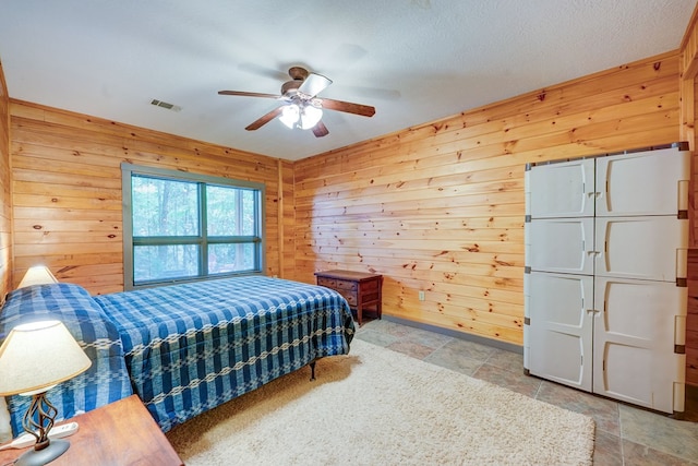 56 Laurel Dr, Blue Ridge, GA 30513 - bedroom featuring wooden walls, ceiling fan, and stone finish flooring