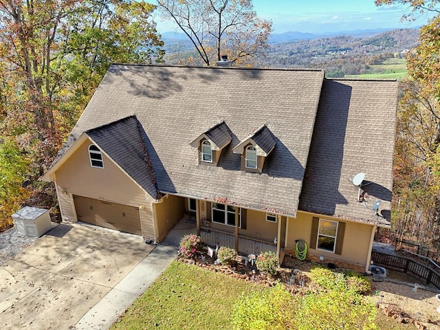 view of front of property featuring a garage, covered porch, and a mountain view