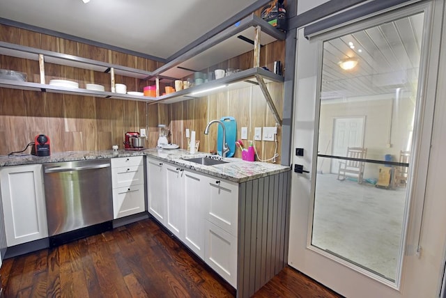 kitchen featuring light stone countertops, white cabinetry, sink, stainless steel dishwasher, and dark hardwood / wood-style floors