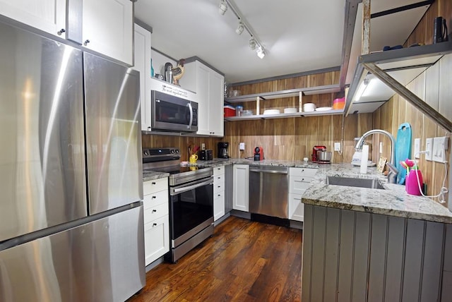 kitchen with light stone counters, sink, white cabinets, and stainless steel appliances