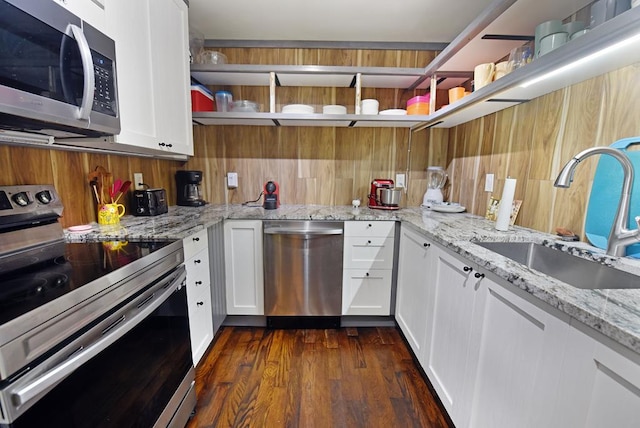 kitchen with white cabinetry, sink, light stone counters, and appliances with stainless steel finishes