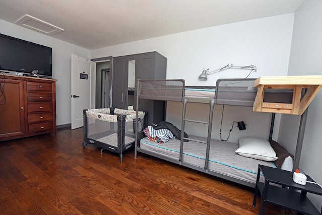 bedroom with dark hardwood / wood-style floors