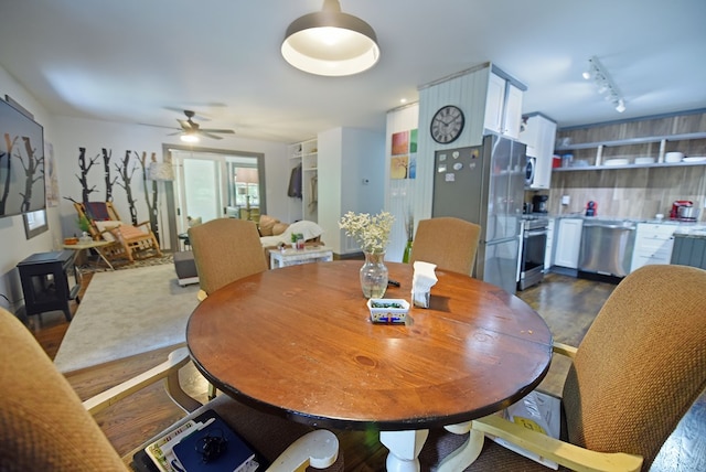 dining space with ceiling fan and track lighting