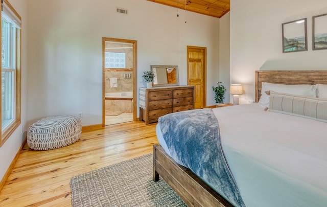 bedroom with connected bathroom, hardwood / wood-style flooring, vaulted ceiling, and wood ceiling