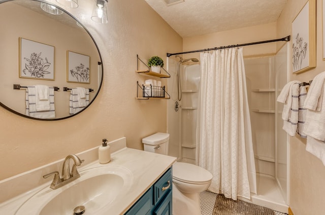 bathroom featuring toilet, vanity, a textured ceiling, and walk in shower