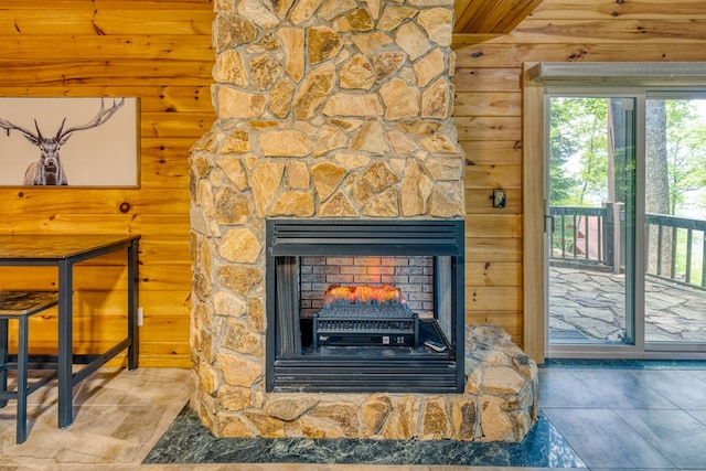 interior details featuring a stone fireplace and log walls