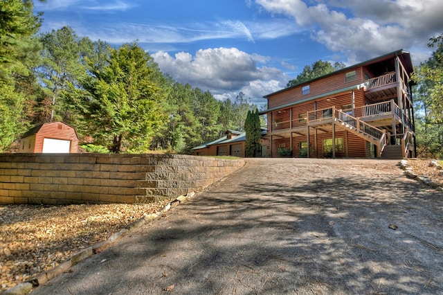 view of home's exterior with fence, a garage, and log veneer siding