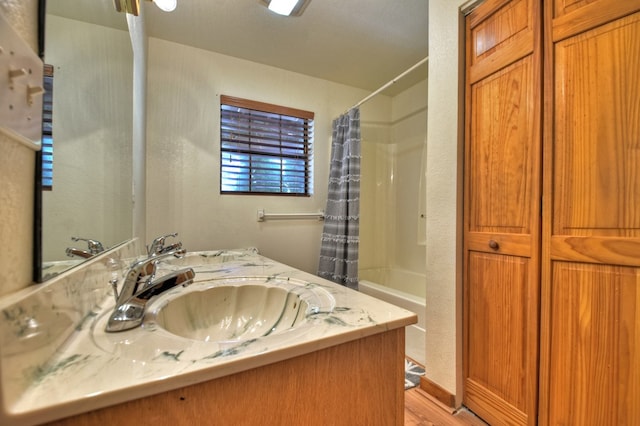 full bath featuring wood finished floors, vanity, and shower / bathtub combination with curtain