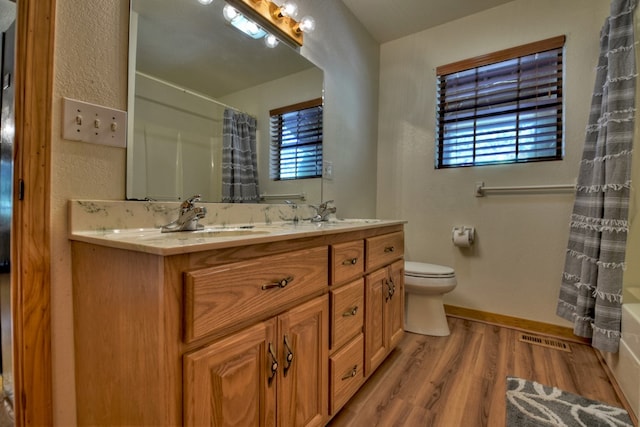 full bath featuring wood finished floors, visible vents, a sink, and a healthy amount of sunlight