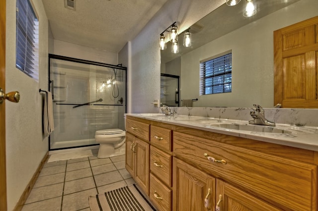 bathroom with visible vents, tile patterned floors, a stall shower, and a sink