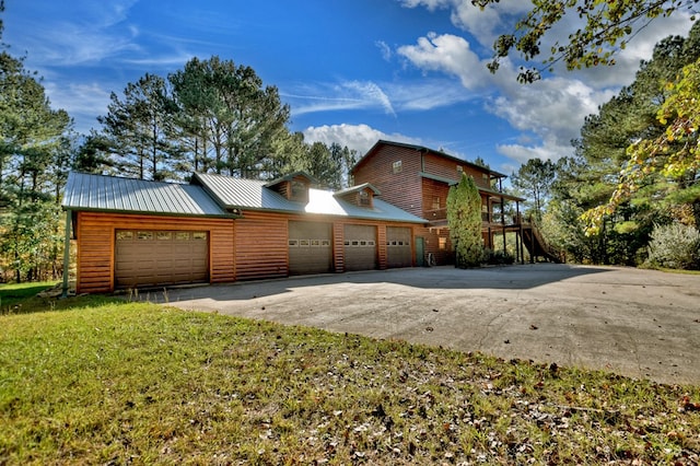 view of front facade with a front lawn, driveway, and metal roof