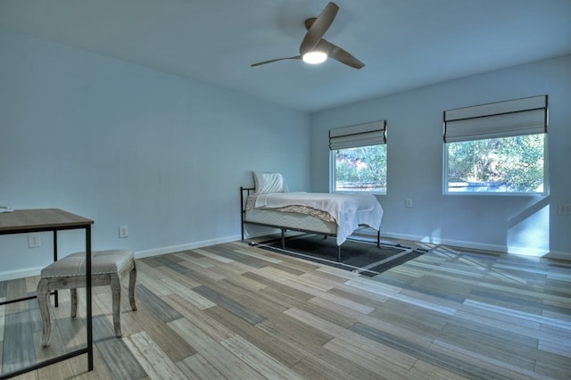 bedroom featuring wood finished floors, a ceiling fan, and baseboards