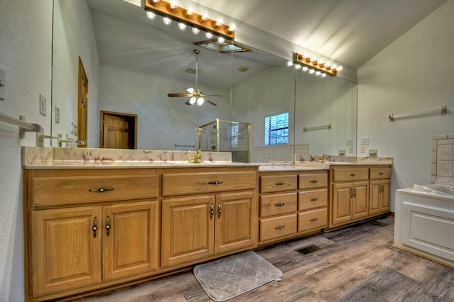 full bathroom featuring a shower stall, double vanity, wood finished floors, a sink, and high vaulted ceiling