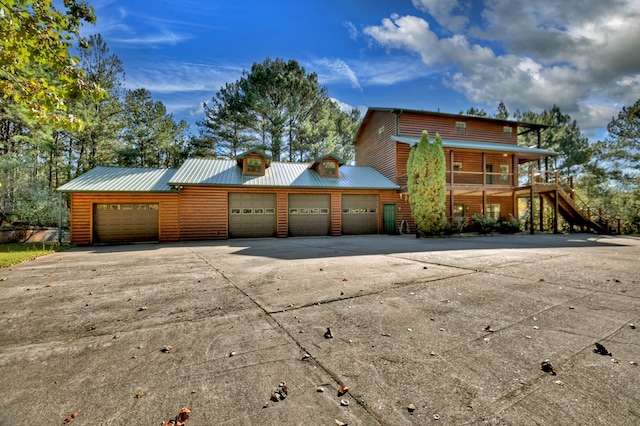 view of front facade with driveway and metal roof
