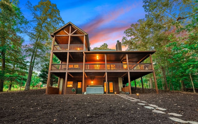 back house at dusk with a wooden deck