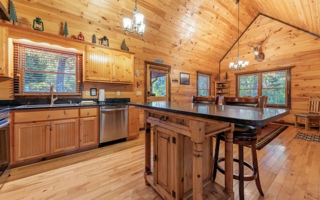 kitchen featuring stainless steel dishwasher, a notable chandelier, hanging light fixtures, and light hardwood / wood-style flooring