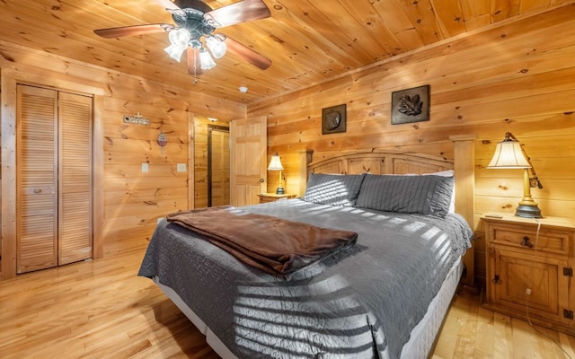 bedroom with ceiling fan, wooden walls, wood ceiling, and light hardwood / wood-style flooring