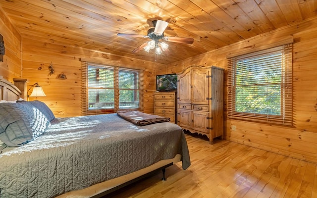 bedroom with wooden walls, light hardwood / wood-style floors, ceiling fan, and wooden ceiling