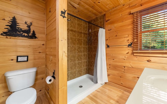 bathroom featuring wooden ceiling, a shower with curtain, sink, wooden walls, and toilet