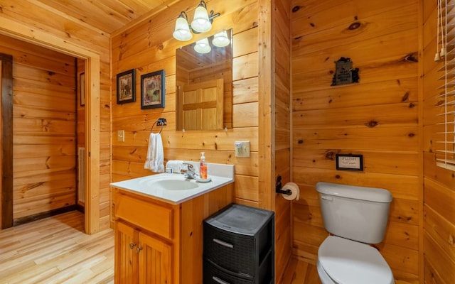 bathroom with wood walls, vanity, wooden ceiling, and toilet