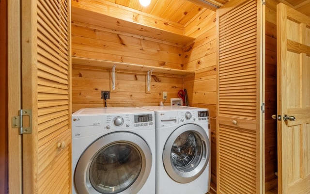 laundry room featuring independent washer and dryer, wooden ceiling, and wood walls