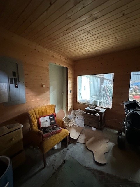 living area with wood ceiling, wood walls, and electric panel