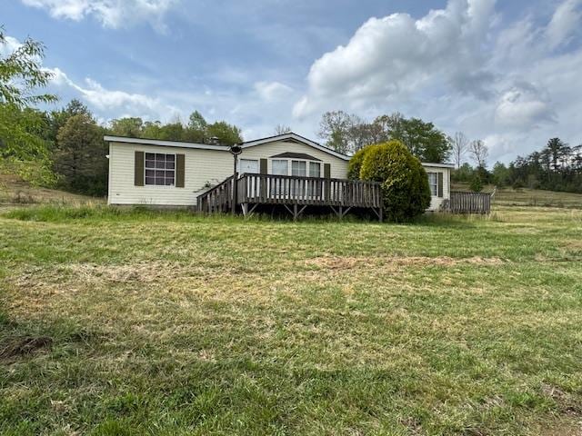 back of property featuring a lawn and a deck