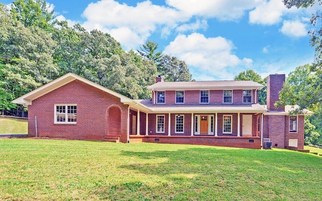 rear view of property featuring a lawn, covered porch, and central AC