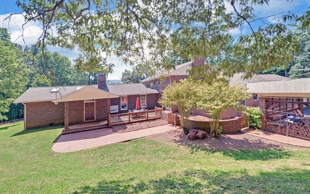 rear view of house with a lawn and a deck