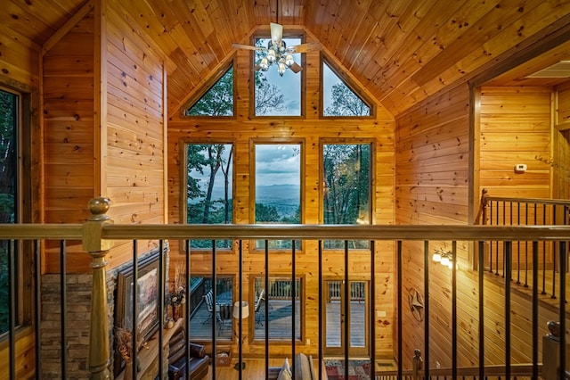 interior space with wooden walls, wooden ceiling, ceiling fan, and vaulted ceiling