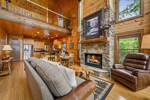 living area featuring light wood-type flooring, wood walls, and a high ceiling