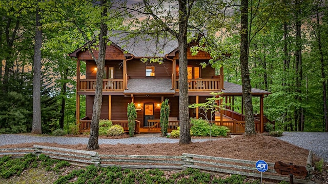 view of front of home featuring a porch, a balcony, and roof with shingles