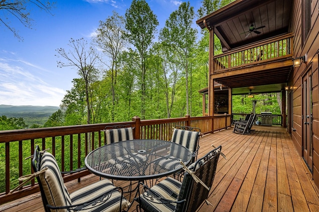 wooden deck featuring ceiling fan and outdoor dining space
