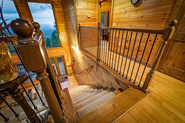 staircase featuring wood walls and wood finished floors