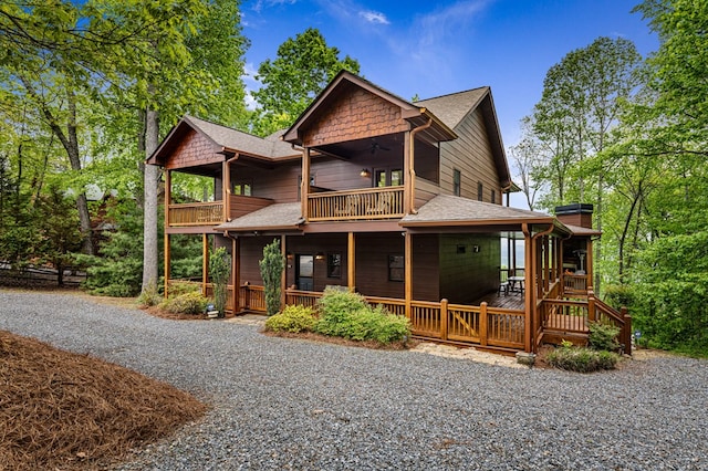 view of front of home with ceiling fan, a shingled roof, and a balcony