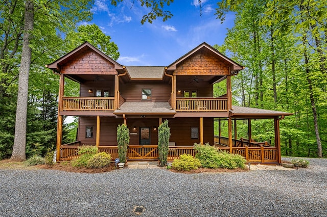 chalet / cabin featuring a ceiling fan, a shingled roof, a porch, and a balcony